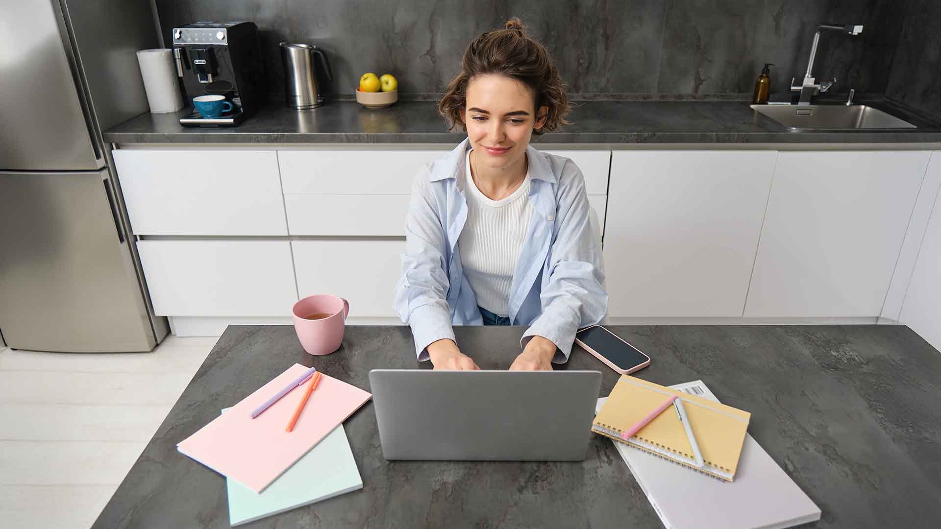 Working from home with a laptop and promotional gifts, reinforcing brand presence and daily motivation.